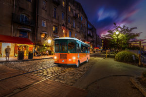 Savannah trolley driving past river street at night