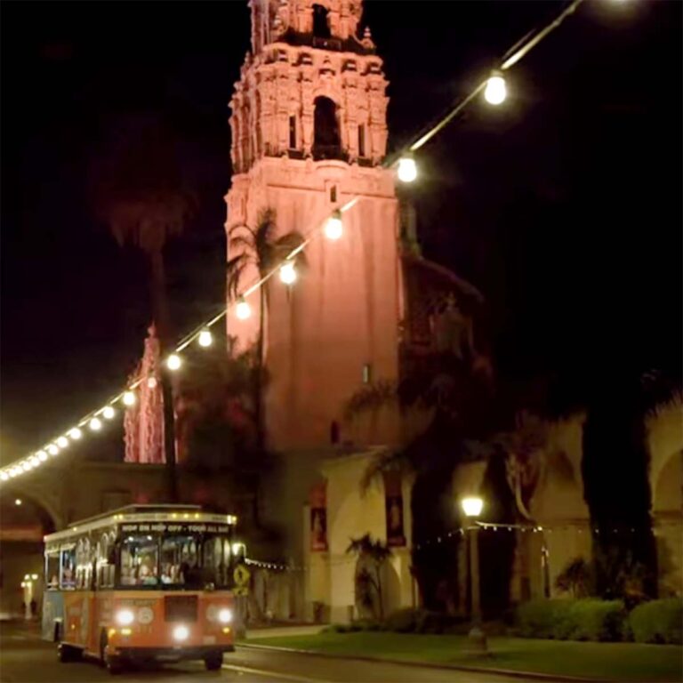 San Diego City Lights Night Tour trolley driving past Museum of Us