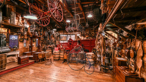 interior of oldest store museum featuring old bikes, barrels, portraits, trunks and may more items