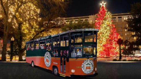 San Antonio holiday trolley surrounded by holiday lights and Christmas tree