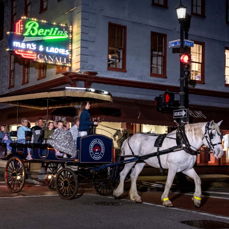 guests riding on an evening ghost tour carriage in Charleston